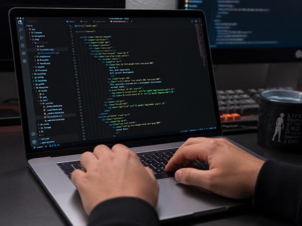 Hands typing code on a laptop keyboard with an editor open on screen